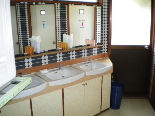 a bathroom with three sinks and a mirror at Asumi Onsen in Fujiyoshida