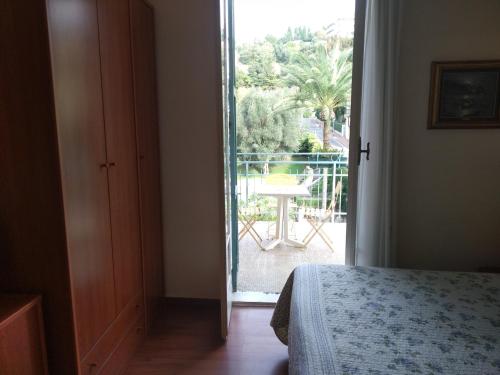 a bedroom with a door open to a patio with a table at Hotel Lucciola in Bordighera