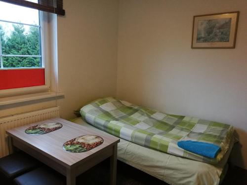 a room with two beds and a table and a window at Dom Wczasowy Pięciu Pomostów in Czaplinek