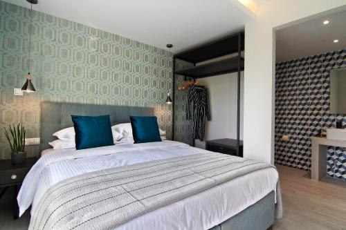 a bedroom with a large bed with blue pillows at Maison 66, Riviera Hotels in Athens