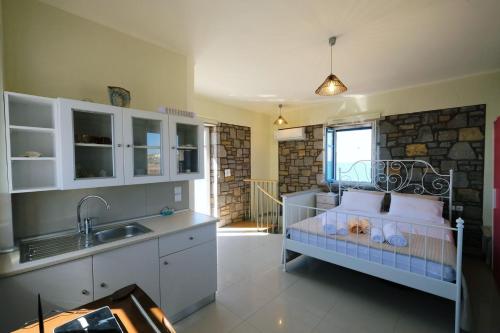 a kitchen with a bed and a sink in a room at Fanaraki villas in Moudhros