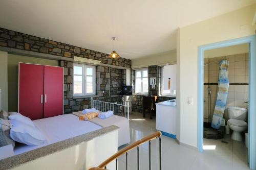 sypialnia z dużym łóżkiem i łazienką w obiekcie Fanaraki villas w mieście Moúdhros