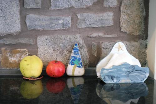 three vases sitting on a table in front of a brick wall at Fanaraki villas in Moudhros