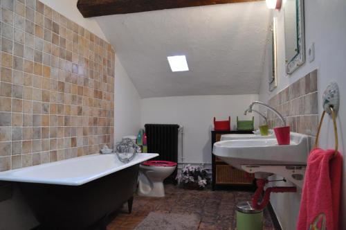 een badkamer met een bad, een wastafel en een toilet bij Villa Castel Chambres d'hôtes in Rillieux