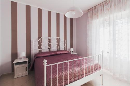 Dormitorio infantil con cuna blanca y paredes a rayas en Guest House " Chilli & Chocolate", en Pompeya