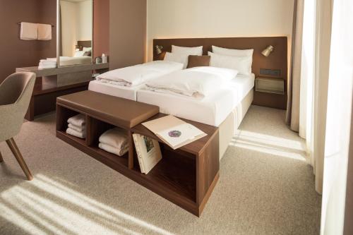 1 Schlafzimmer mit einem Bett und einem Schreibtisch sowie einem Bett der Marke sidx sidx sidx. in der Unterkunft Das ACKER Hotel in Neuburg an der Donau
