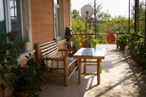 a wooden bench and a table on a patio at Country House Uliana in Tskaltubo