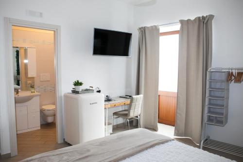 a bedroom with a bed and a desk and a television at Vicolo 8 in Sorrento