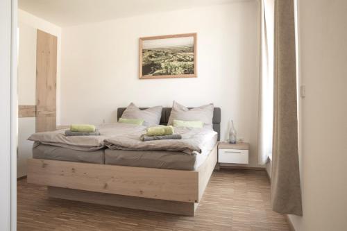 een slaapkamer met een bed met een foto aan de muur bij Ferienwohnung am Weingut Eisenbock in Strass