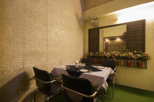 a dining room with a table and chairs and a mirror at Hotel Sunstar Heights in New Delhi