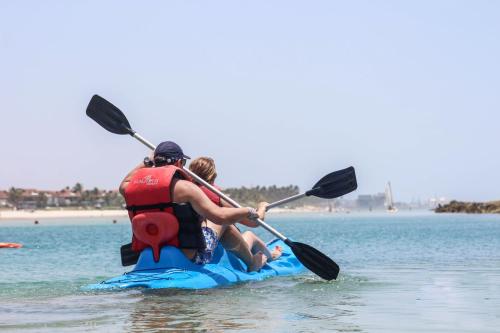 two people on a paddle board on the water at Samoa Beach Resort in Porto De Galinhas