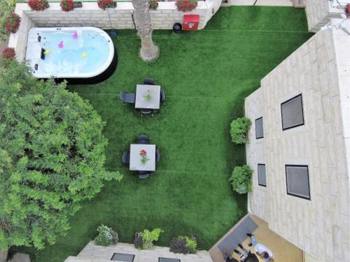 an overhead view of a lawn with tables and a pool at Hotel La Finca - Luxury Suites Hotel in Beer Sheva