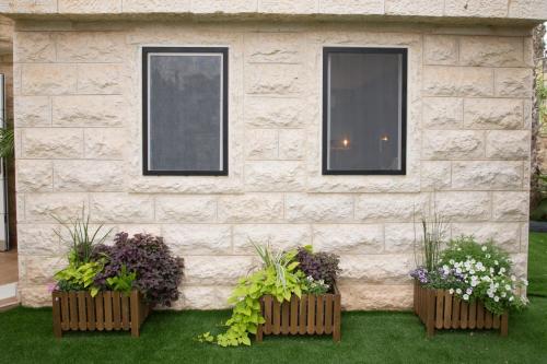 a building with two windows and three flower boxes at Hotel La Finca - Luxury Suites Hotel in Beer Sheva