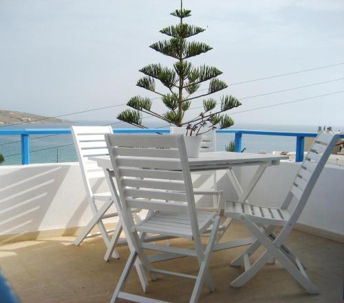 einen Tisch und Stühle mit einem Weihnachtsbaum auf dem Balkon in der Unterkunft Corina Apartments , Corina 2-studios in Sitia