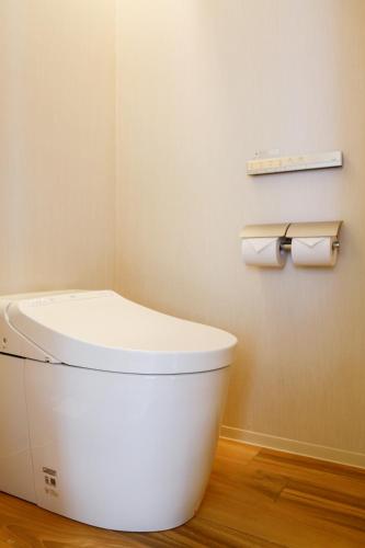 a bathroom with a toilet and two rolls of toilet paper at Hotel Comfact in Tokyo