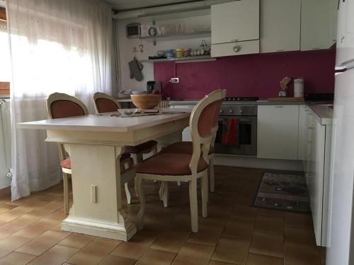 eine Küche mit einem Tisch mit Stühlen und einer Arbeitsplatte in der Unterkunft A pochi passi dal mare in Torre del Lago Puccini