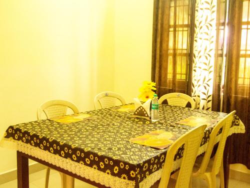 a dining room table with chairs and a table cloth at Skylarc Inn in Ooty