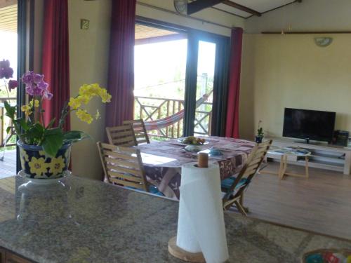 a living room with a dining table and a television at Chez Solange et Michel in Sainte-Rose