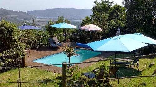 a deck with umbrellas and a swimming pool at Panorama Lodge in Knysna