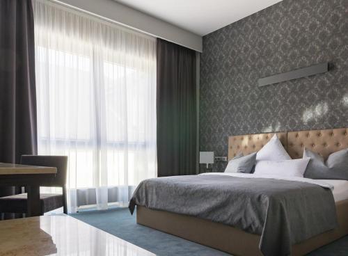 1 dormitorio con cama, escritorio y ventana en anders Kontorhaus Hotel, en Lüneburg