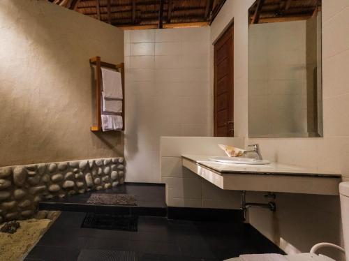 ein Bad mit einem Waschbecken und einem Spiegel in der Unterkunft Kimo Resort Pulau Banyak Aceh Singkil in Alaban