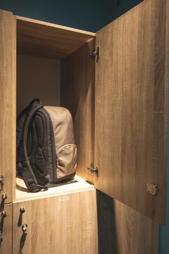 a backpack is sitting inside of a wooden cabinet at Vibrant Hostel in Kota Kinabalu