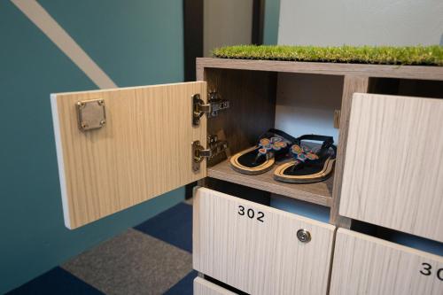 a pair of sandals sitting in a wooden box at Vibrant Hostel in Kota Kinabalu