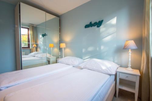 ソポトにあるGrand Apartments - Nautica Deluxe Apartmentのベッドルーム(大きな白いベッド1台、鏡付)