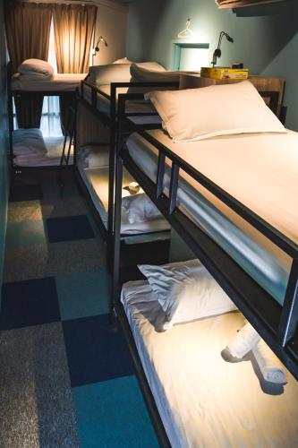 a room with two bunk beds and a checkered floor at Vibrant Hostel in Kota Kinabalu