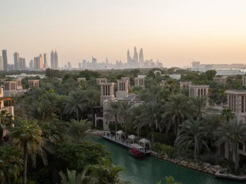 a view of the city of dubai with a boat in a river at Jumeirah Dar Al Masyaf Dubai in Dubai