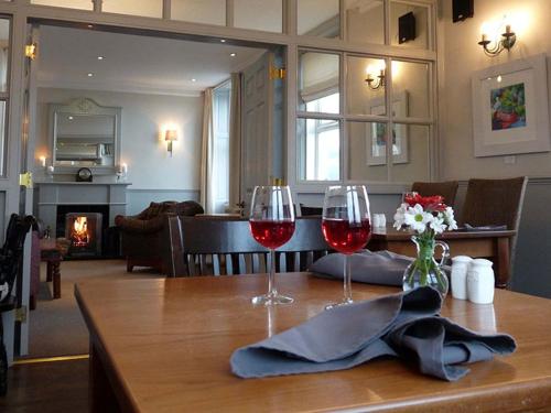 a table with two glasses of red wine on it at Bayview Cottage in Lamlash