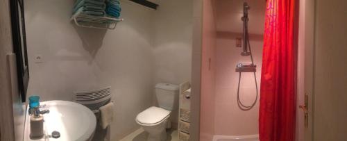 La salle de bains est pourvue de toilettes et d'un rideau de douche rouge. dans l'établissement Les Granges d'Ignaux, à Ignaux