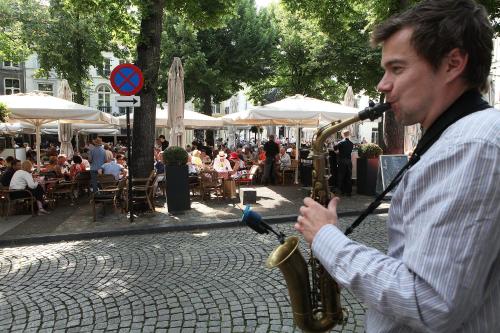 a man playing a saxophone on a city street at Derlon Hotel Maastricht in Maastricht