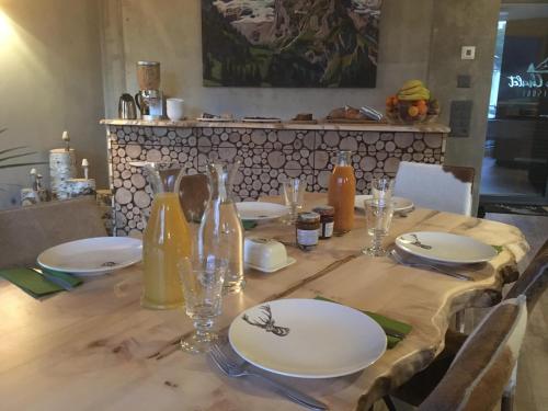 a wooden table with plates and glasses on it at Mountain Chalet Amden in Amden