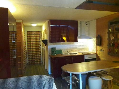 une cuisine avec une table et un comptoir dans l'établissement SKI Sun 3212, à Manigod