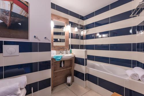 a bathroom with blue and white tiles on the wall at Résidence Pierre & Vacances Premium Le Coteau et la Mer in Tréboul
