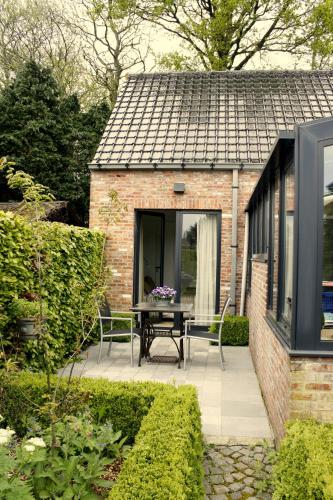 a house with a patio with a table and chairs at B&B De Kastanjeboom in Jabbeke