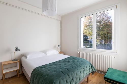 une chambre avec un lit et une grande fenêtre dans l'établissement LE TIMONIER by Cocoonr, à Saint-Malo