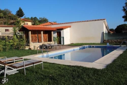 a swimming pool in the yard of a house at Casa da Capela in Paredes de Coura