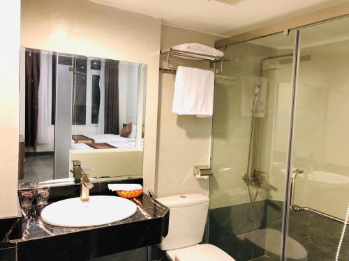 a bathroom with a toilet and a sink and a shower at Nice Hue Hotel in Hue