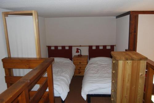 une chambre avec deux lits et un lit superposé dans l'établissement LE Refuge 4005, à Manigod