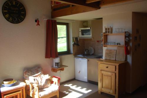 a small kitchen with a refrigerator and a table at LE Refuge 4005 in Manigod