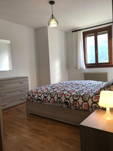 a bedroom with a bed and a dresser and a window at Snow Home Apartment - CIPAT 022093-AT-381181 in Giustino