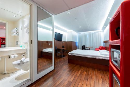 ユヴァスキュラにあるオメナ ホテル ユヴァスキュラのベッドとバスルーム付きのホテルルームです。