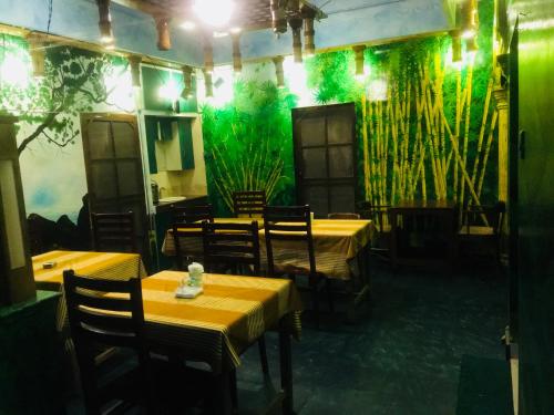 a restaurant with tables and chairs and a green wall at Bastian Homestay in Cochin