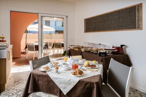 ein Esszimmer mit einem Tisch mit Essen drauf in der Unterkunft Le Terrazze di Bellavista in Su Forti