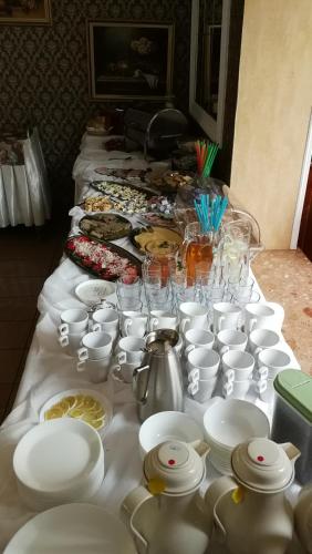 科贝拉古拉Bed&Breakfast Maciejanka的一张桌子上摆放着白色盘子、杯子和碟子。