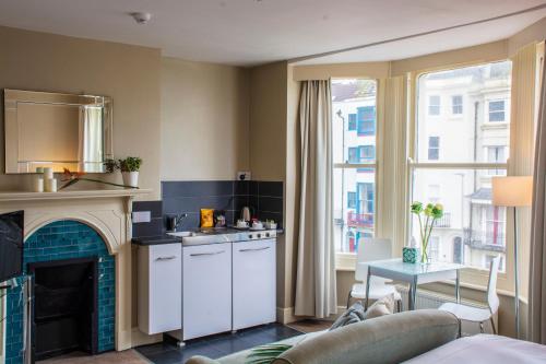 a kitchen with a living room with a fireplace at Amherst Brighton in Brighton & Hove