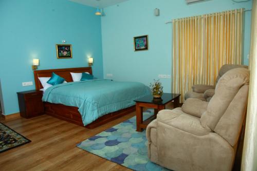 a bedroom with a bed and a chair and a couch at Zenha Resorts in Munnar