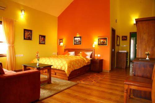 a bedroom with a bed and a couch at Zenha Resorts in Munnar
